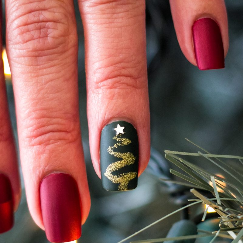 a hand applying glitter nail polish with a flat nail art brush