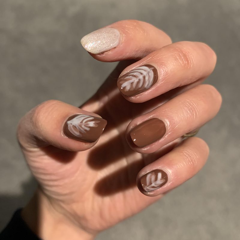 close-up of hands showing popular coffee nail art designs
