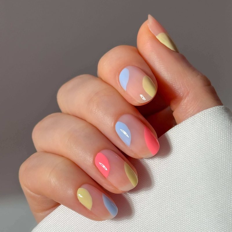 hand caring for nails with pastel nail designs