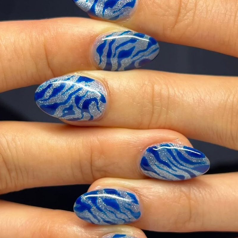 Variety of blue silver nail art designs including glitter and geometric patterns