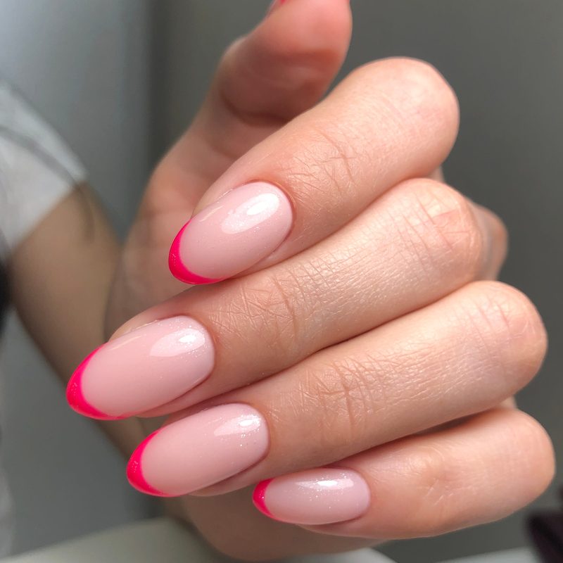 woman applying top coat to maintain bright summer nail art