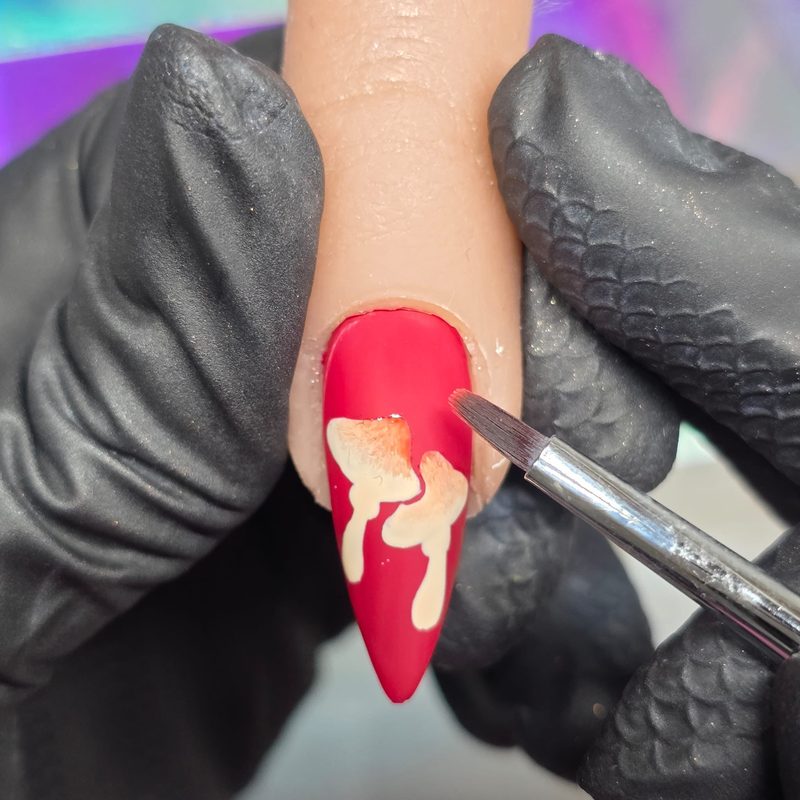 Applying detailed nail art design with a fine nail art brush