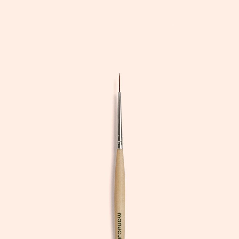 Close-up of a professional liner brush nail art tool with fine bristles