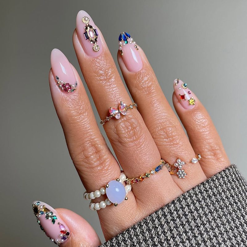 close-up of hand with coordinated nail art and gold jewelry