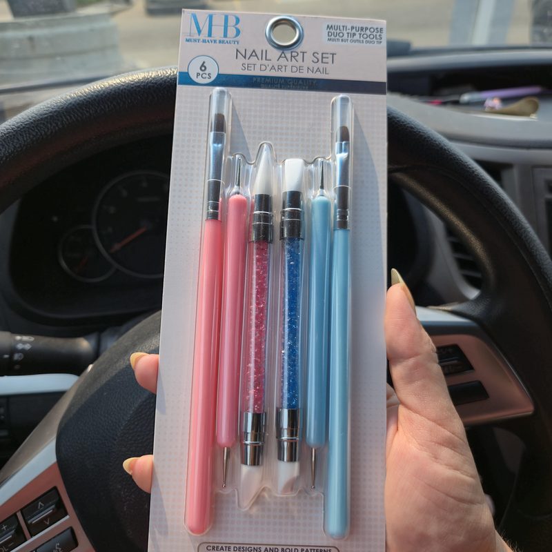 Close-up of nail art pen alongside traditional nail brushes illustrating nail art tools