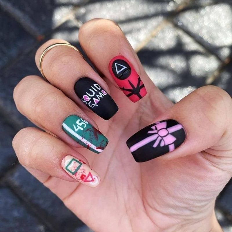 Close-up of squid game nails art featuring geometric shapes and bold colors