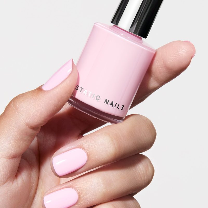 hands receiving nail care treatment to maintain pink ribbon manicure