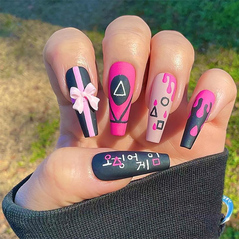 Manicure showcasing triangle, circle, and square symbols in squid game nail art