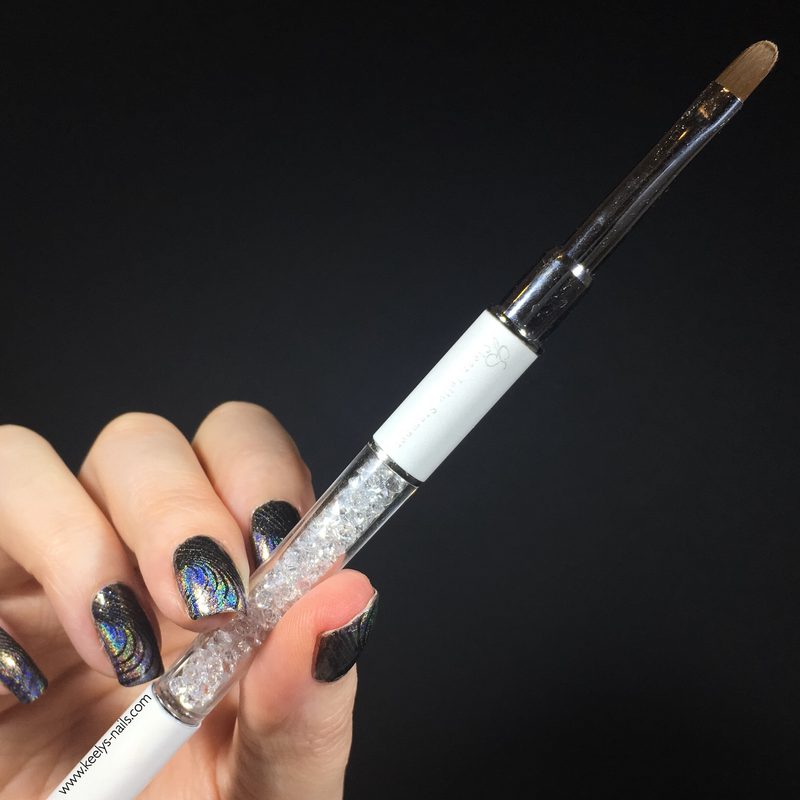 Nail artist applying Swarovski crystals using liner brush