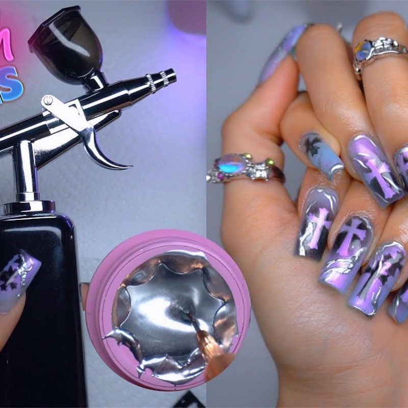 nail artist using an airbrush kit to create nail designs