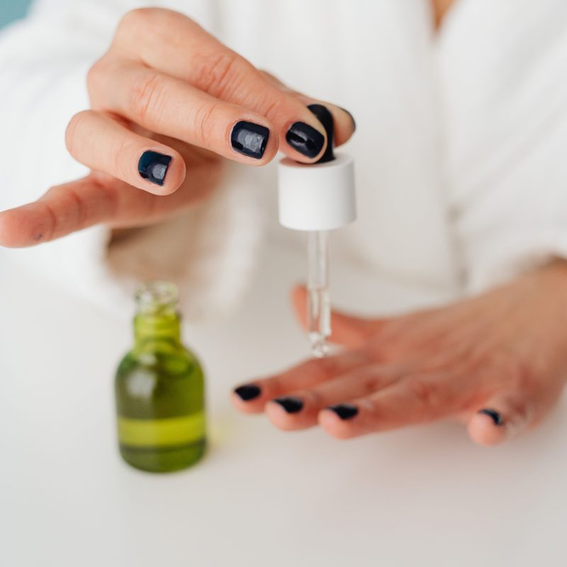 woman caring for nails with cuticle oil after nail salon visit