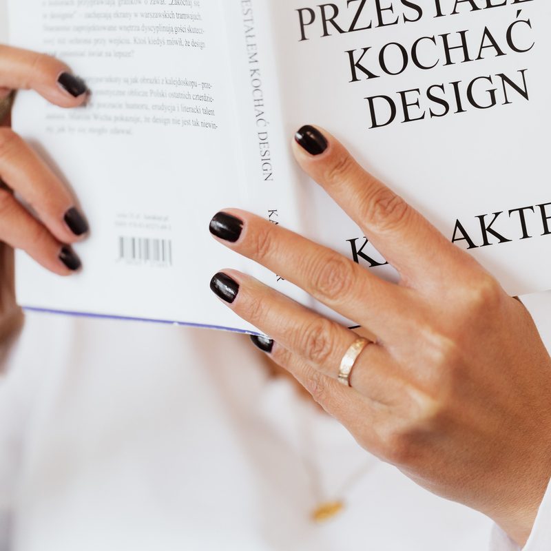 woman reading a nail art design book with manicure ideas