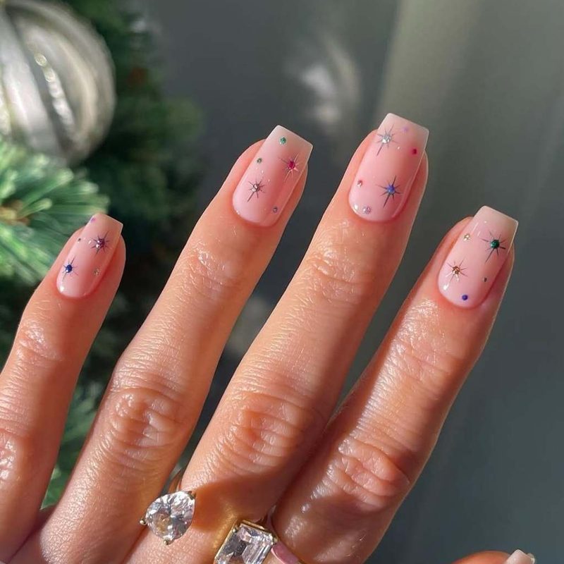 woman's hand with subtle nail art and elegant everyday jewelry