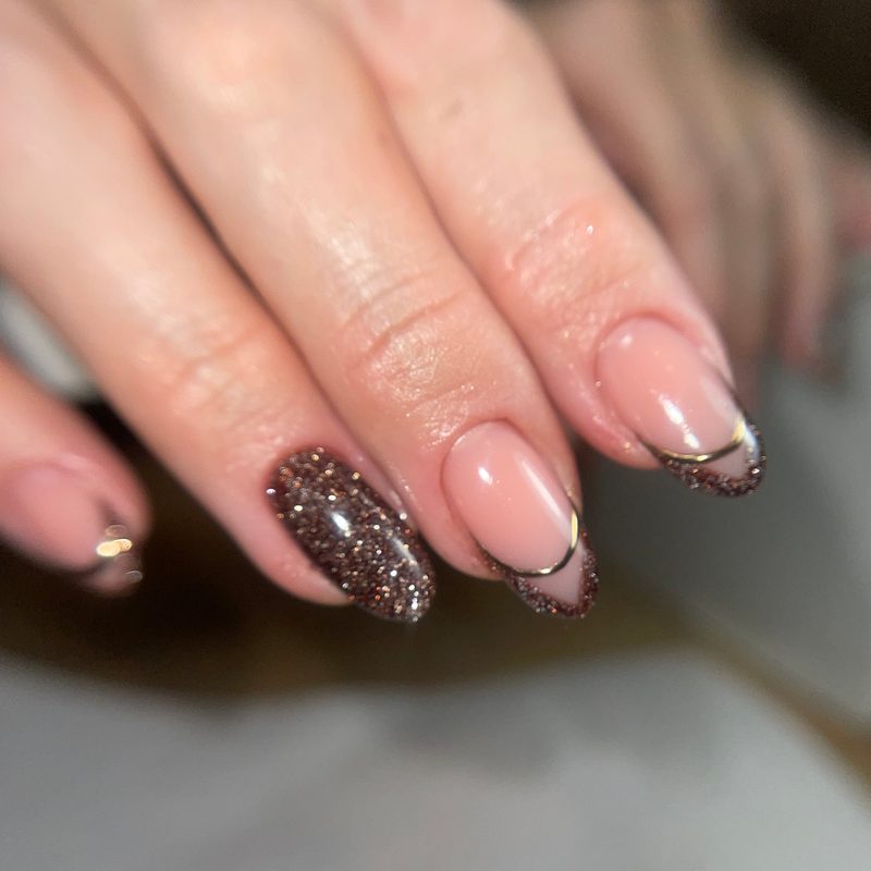 applying fine nail art glitter with brush for precise manicure design