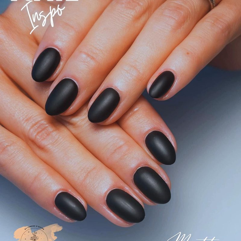 black nails featuring white floral and geometric nail art designs