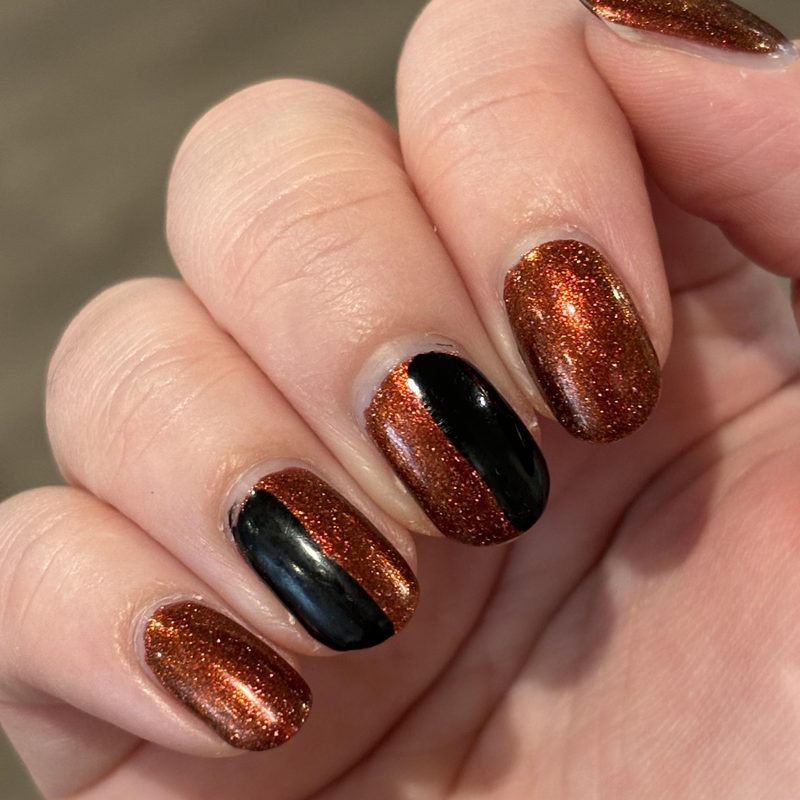 close-up of black nail polish designs with colorful nail art