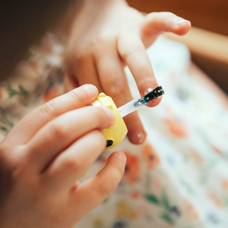 close-up of manicured nails being protected with gloves during cleaning