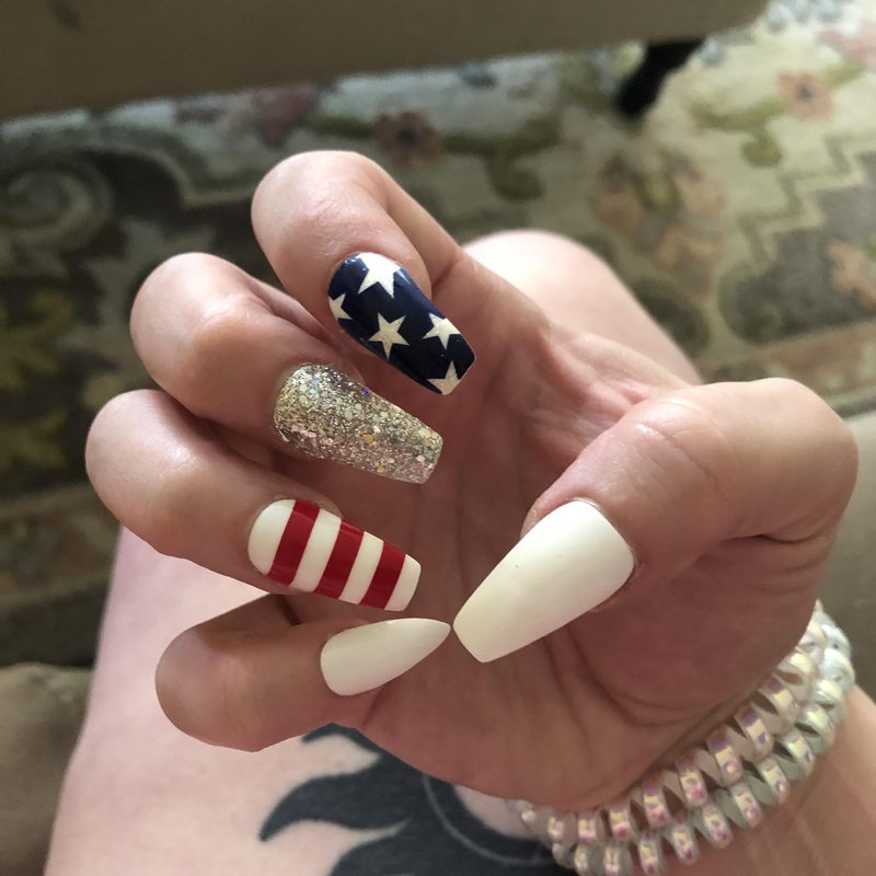 close-up of simple patriotic nail art with red, white, and blue stripes