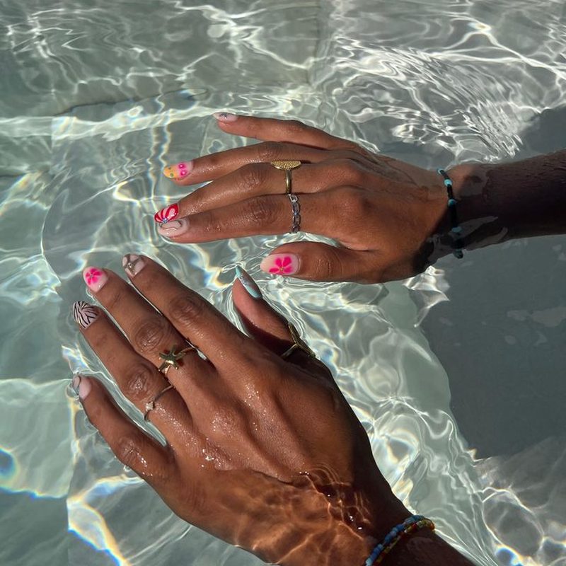 hand applying topcoat to nails during vacation