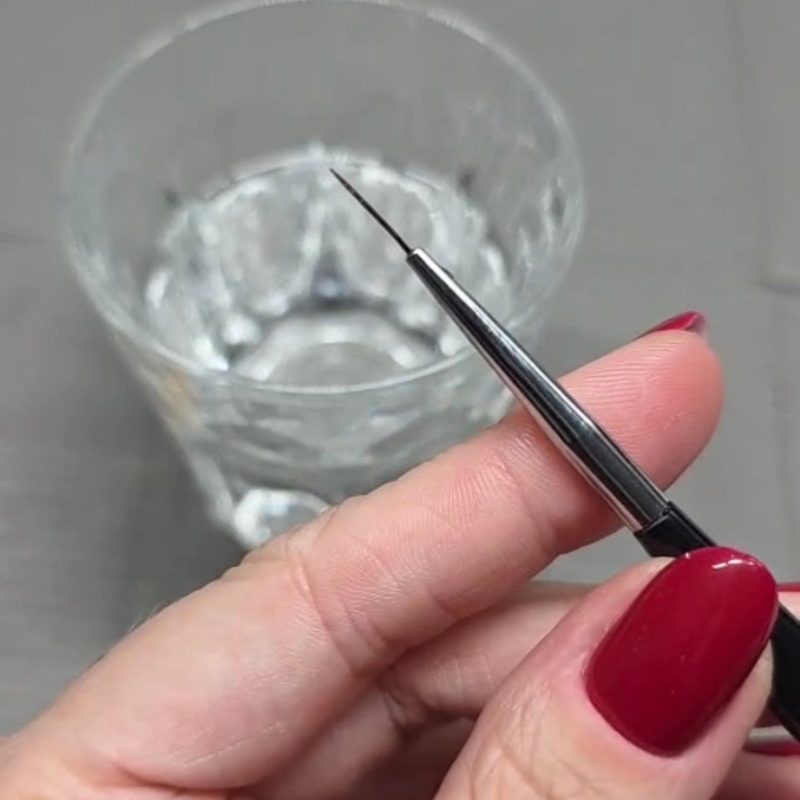 nail art brushes soaking in a specialized brush cleaner