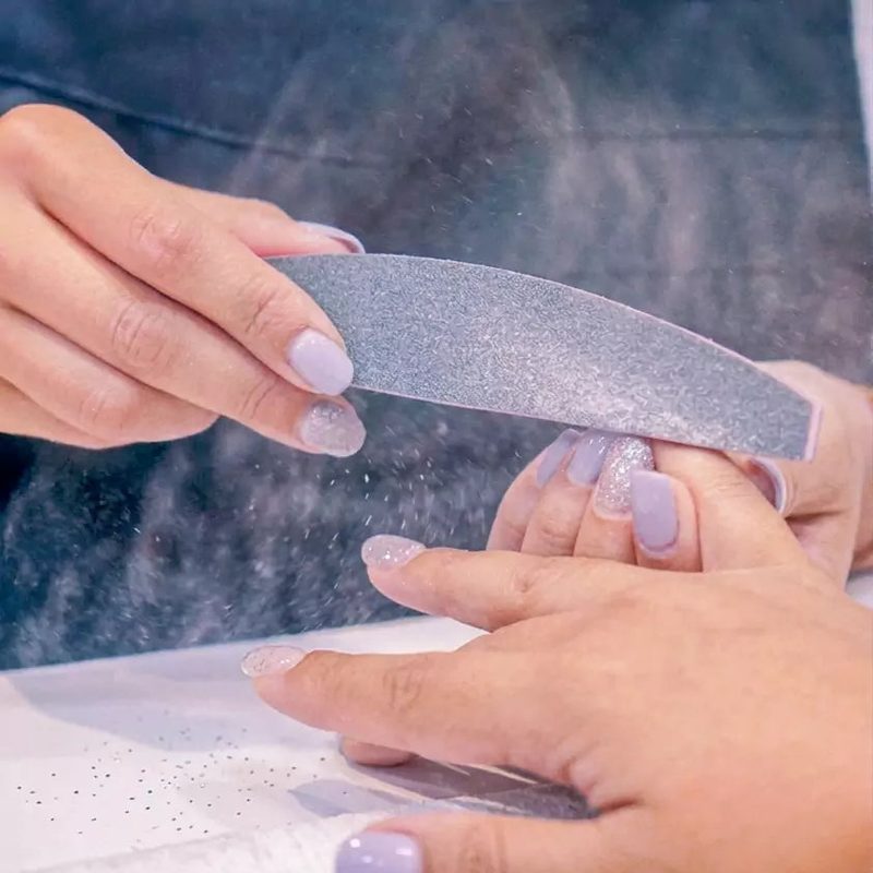 Nail dust particles on nails after filing showing need for nail dust removal