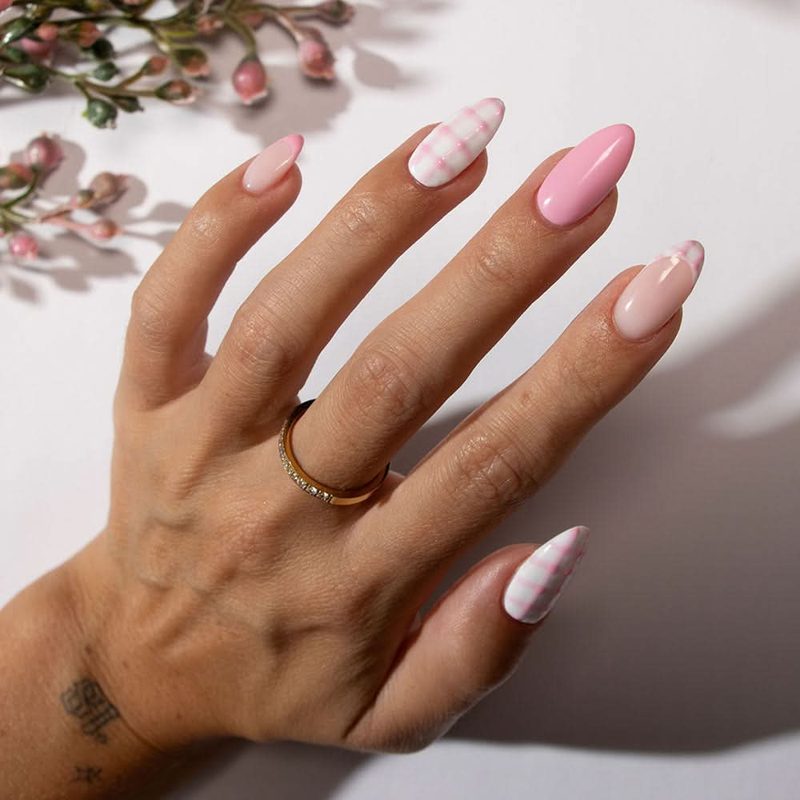 nail technician applying nail art with long liner brush in a salon