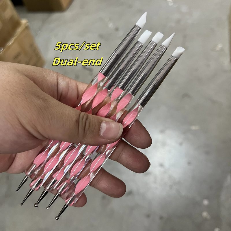various nail art tools including brushes and dotting tools on a table